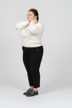 Plump woman in casual clothes suffering from pain in neck