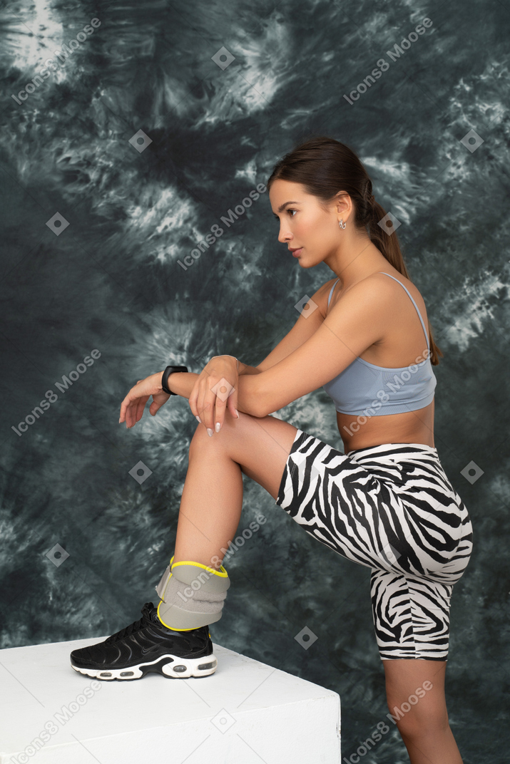 Portrait of a comfortable woman stepping on a cube portrait of a confident woman stepping on a cube