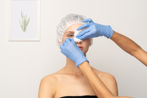 Close-up of doctor putting bandage on patient's nose