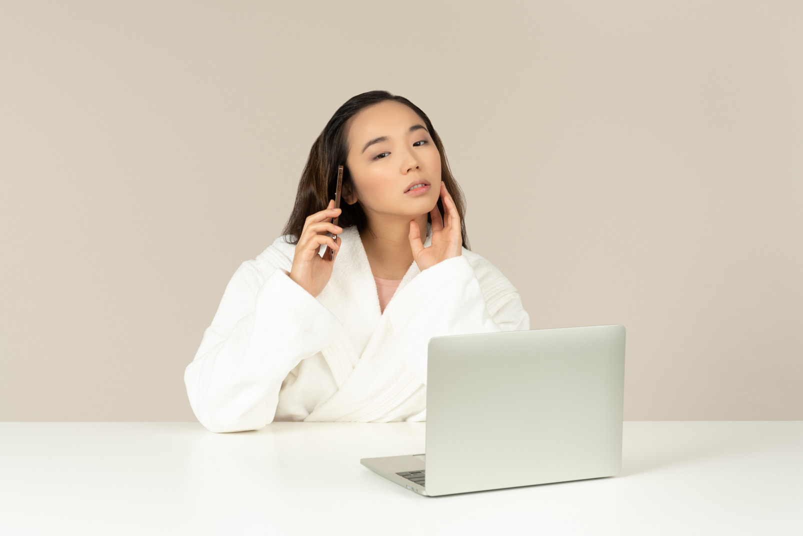 Young asian woman talking on the phone while doing online shopping