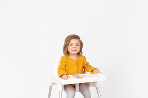 Cute baby girl siting on a highchair