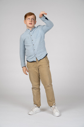 Young boy in blue shirt and khaki pants dropping something