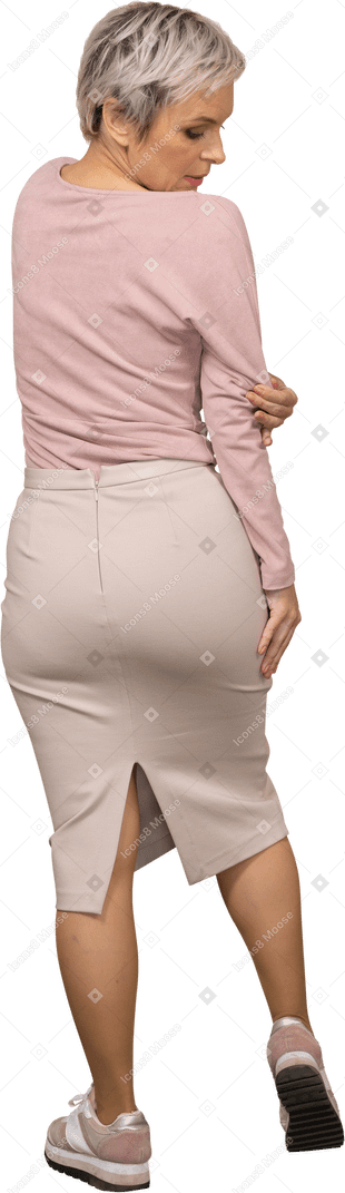 Rear view of a woman in casual clothes looking at her shirt