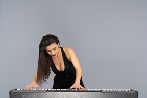 Front view of a young lady in black dress playing the piano