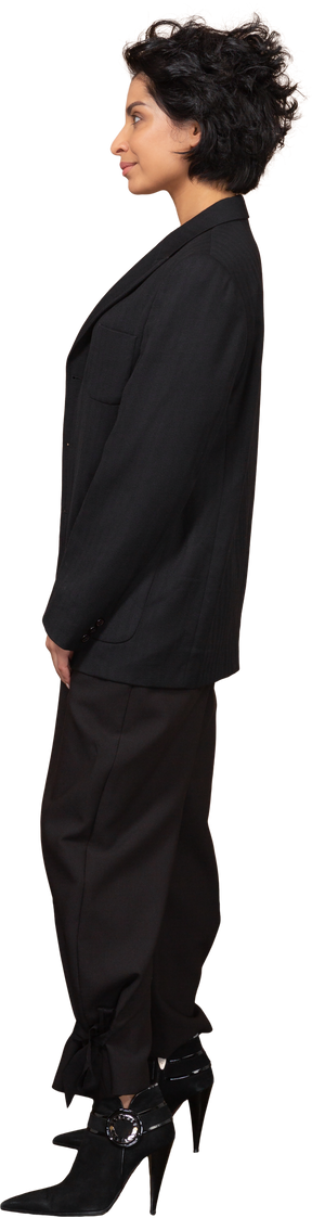 Vista lateral de una empresaria haciendo muecas en un traje negro