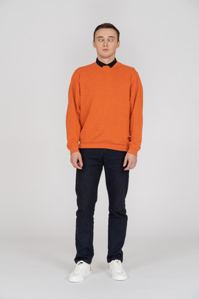 Young man in orange sweatshirt standing