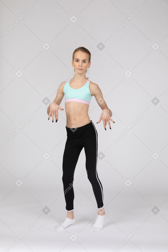 十几岁的女孩在打手势时跳舞的运动服的前视图