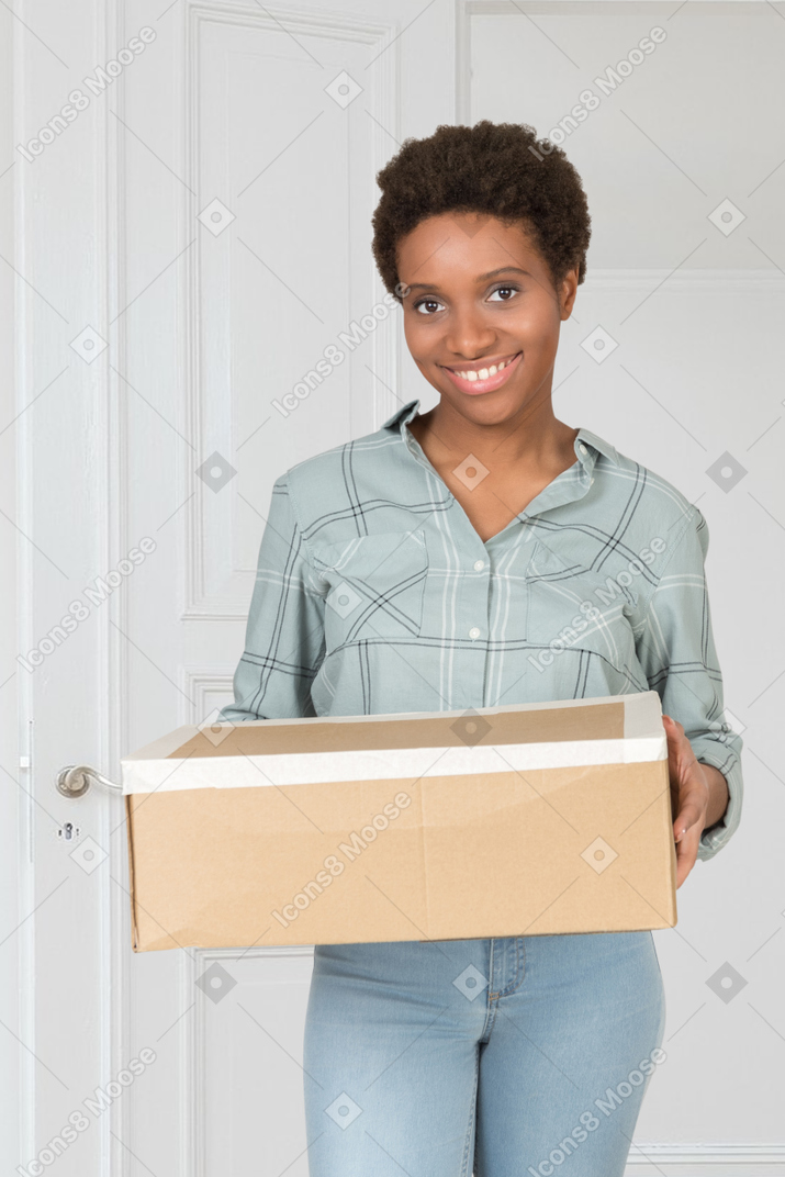 A woman holding a cardboard box in her hands