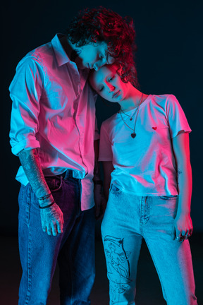 Молодой мужчина и женщина стоят рядом друг с другом в темноте