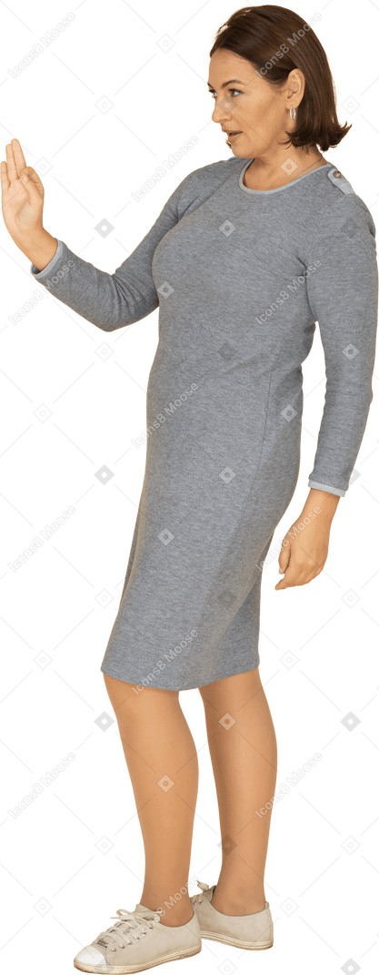 Vista laterale di una donna in abito grigio che mostra segno ok