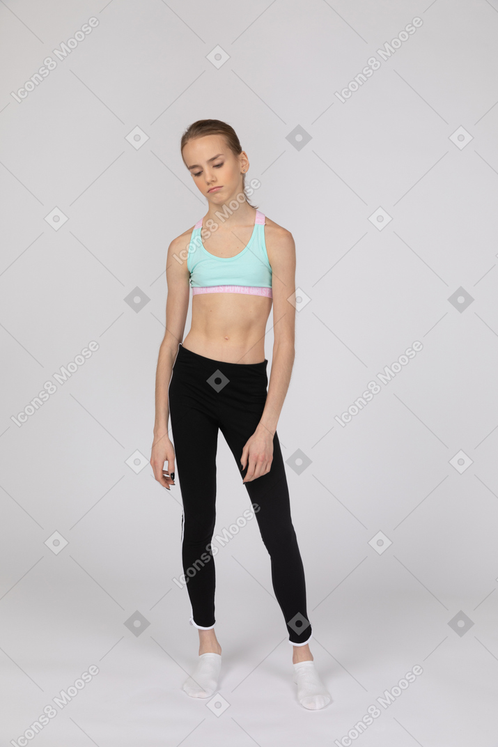 Una adolescente aburrida en ropa deportiva.