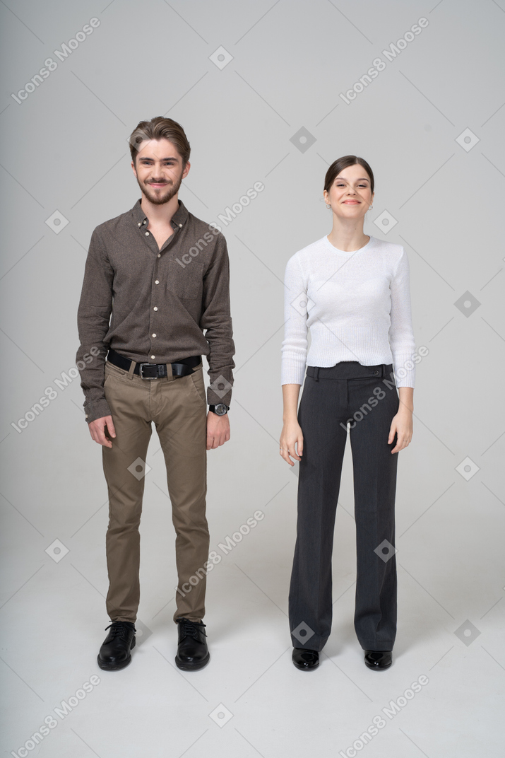 オフィス服で喜んでいる若いカップルの正面図