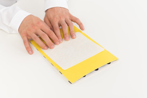 Cropped photo of hands of a man reading braille