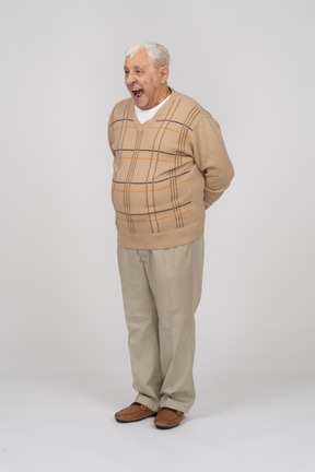 Front view of an old man in casual clothes standing with open mouth