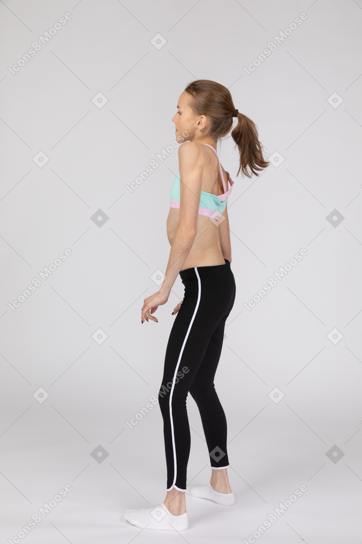 Side view of barefoot adult female in sportswear doing Shoulder