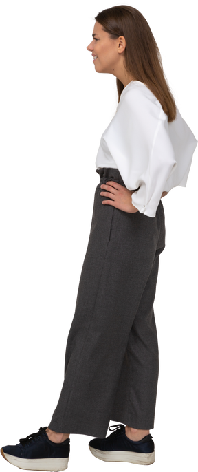 Vista laterale di una giovane donna confusa in abiti da ufficio che mette le mani sui fianchi