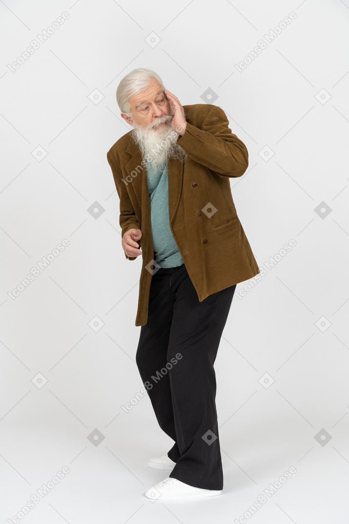 Old man having headache and rubbing his temple