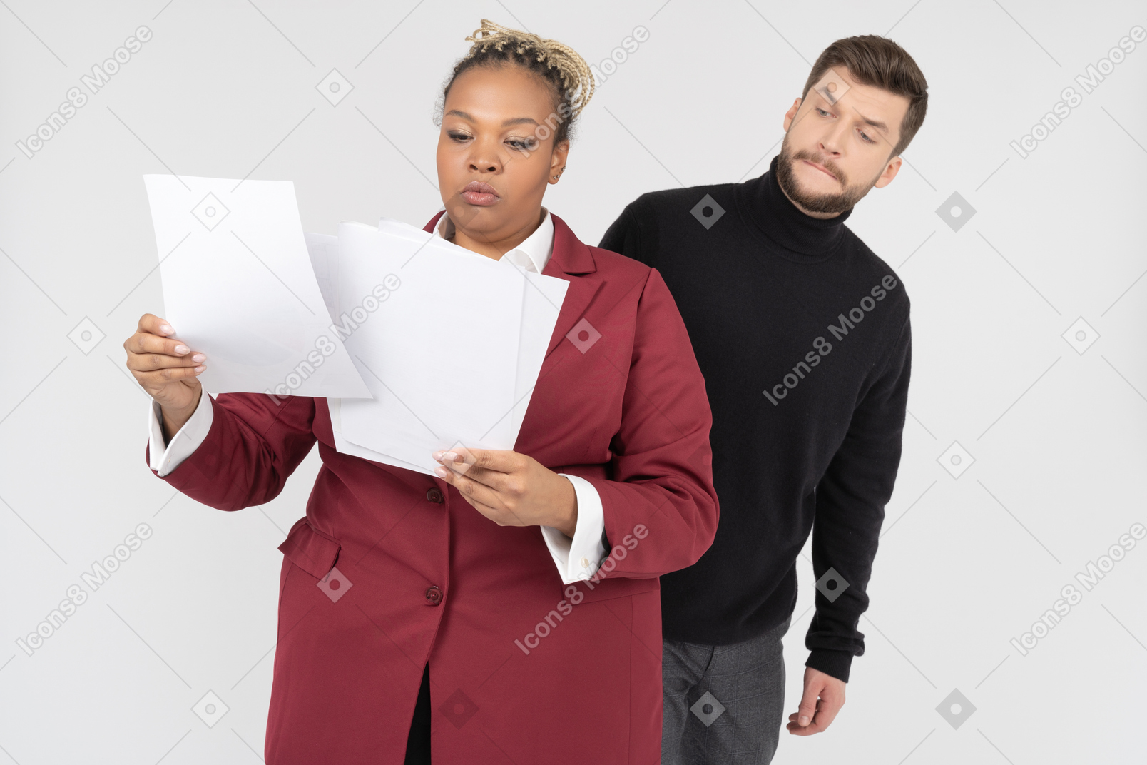Office worker squinting at papers in hand of his female colleague