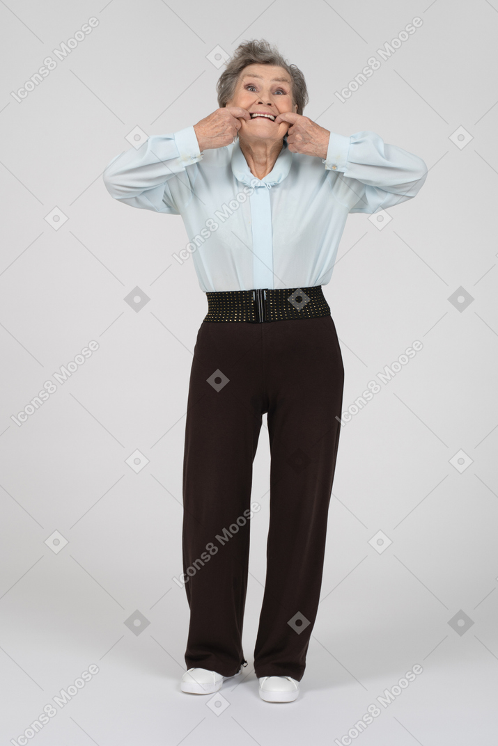 Vista frontal de una anciana haciendo muecas