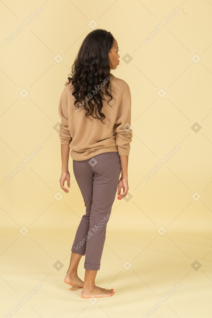 Vista posteriore di una giovane donna in abiti casual a piedi