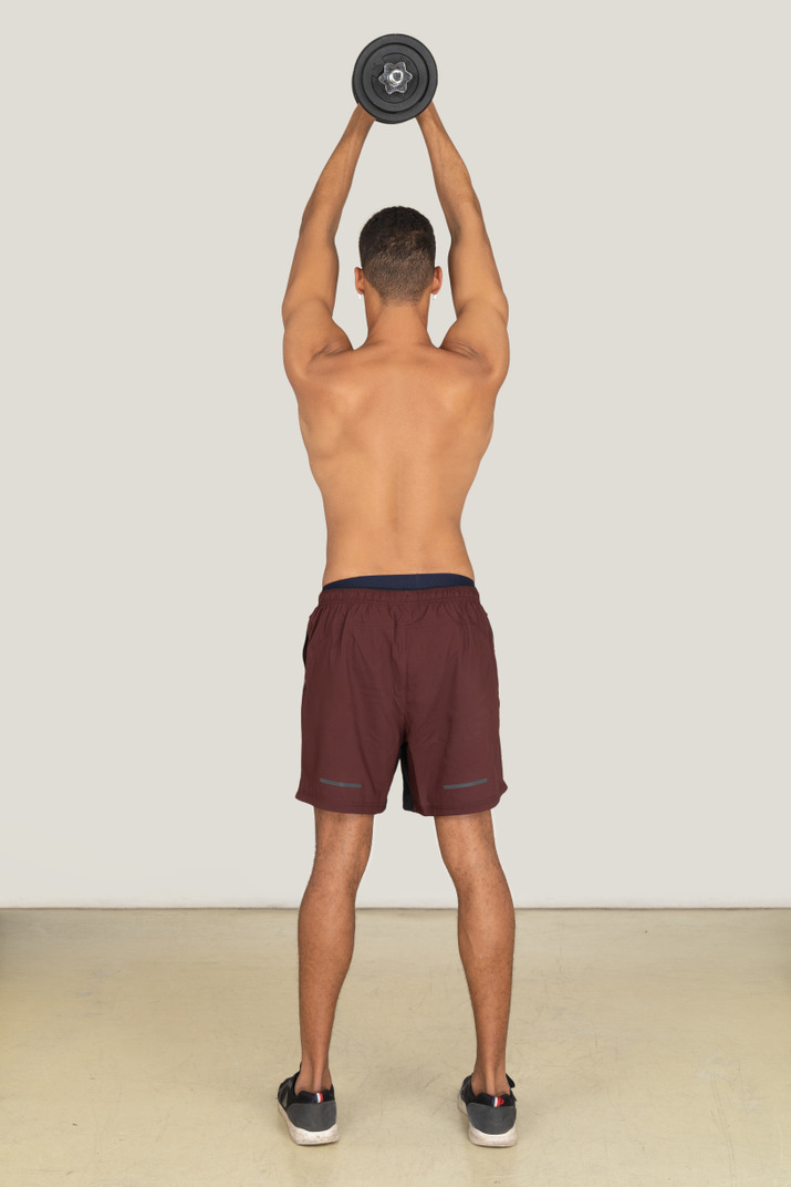 A back side view of the muscular young guy dressed in red shorts