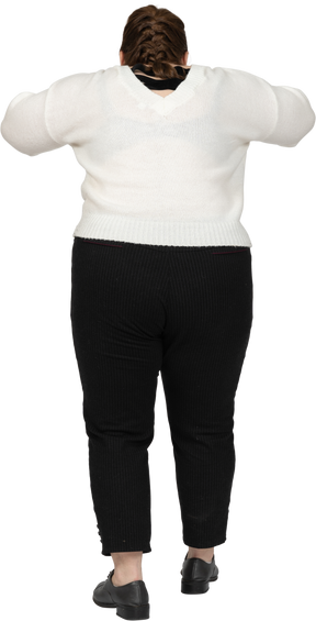 Rear view of a plump woman in casual clothes posing