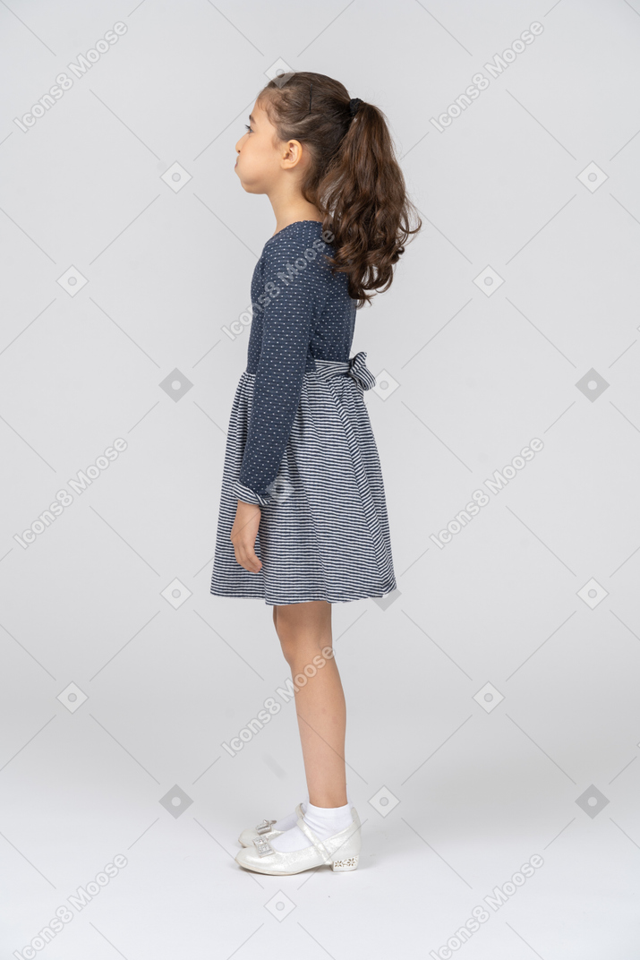 Side view of a girl with her cheeks puffed out