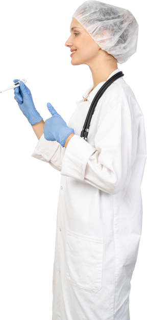 Vista laterale di una giovane dottoressa con lo stetoscopio che tiene il termometro e mostra il pollice in su