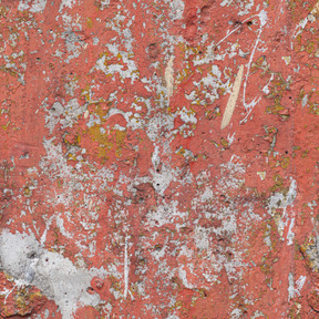 Concrete wall covered with many layers of old paint