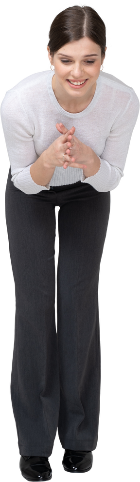 Front view of a happy woman in suit bending down