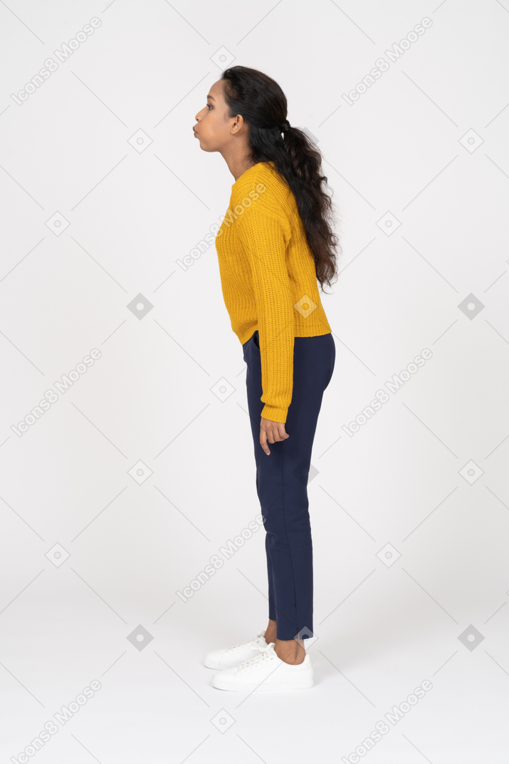 Side view of a girl in casual clothes inflating cheeks