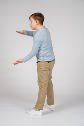 Vista lateral de um menino mostrando o tamanho de algo