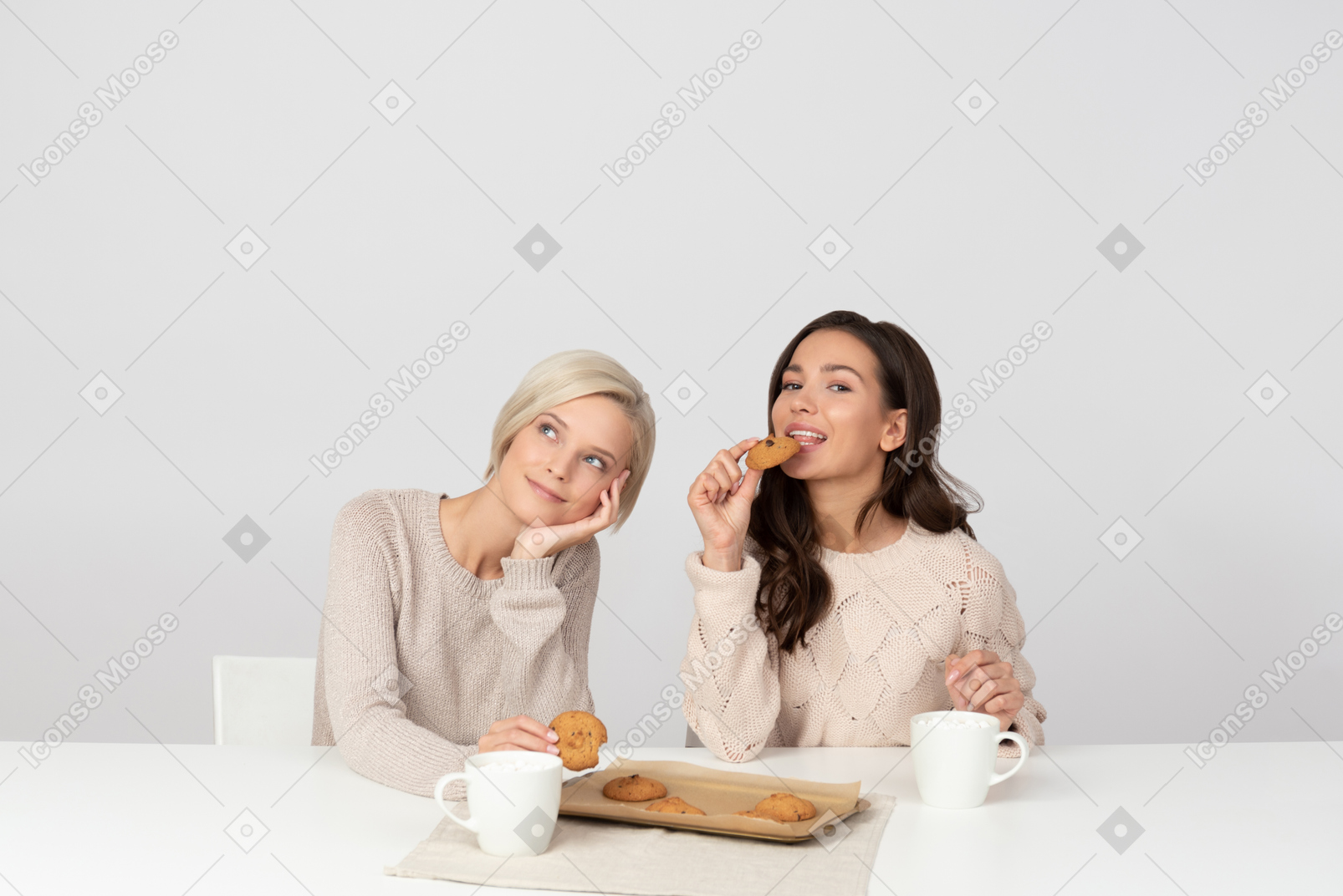 Young women eating homemade cookies and drinking coffee
