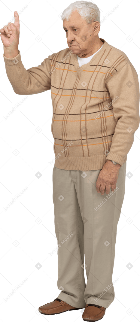 Vista frontal de un anciano con ropa informal apuntando hacia arriba con un dedo