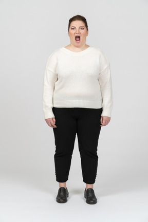 Extremely surprised plump woman in casual clothes looking at camera