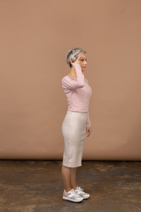 Vista laterale di una donna in abiti casual che tocca la testa con un dito