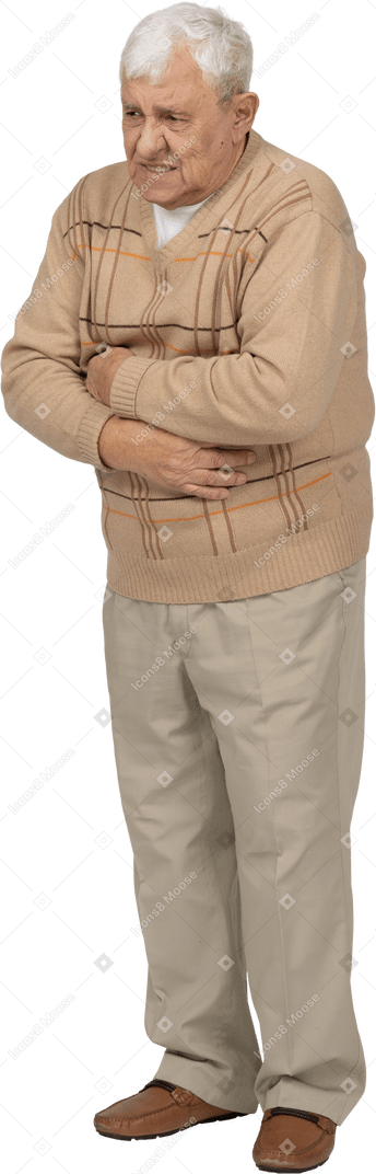 Front view of an old man in casual clothes suffering from stomachache