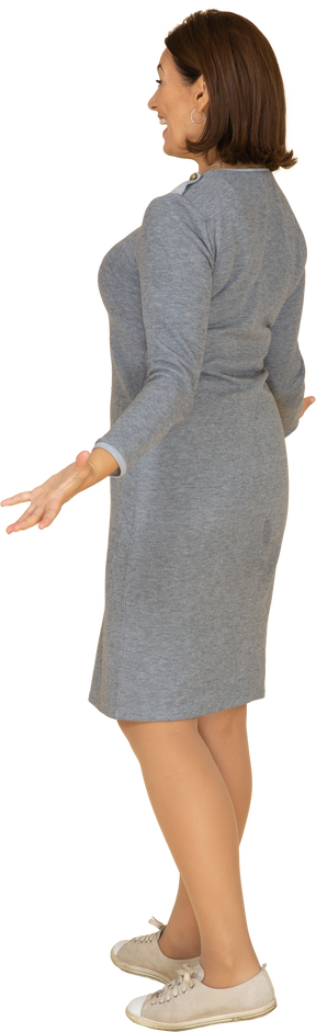 Vista lateral de uma mulher de vestido cinza gesticulando