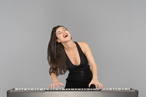 A happy young woman enjoying playing piano