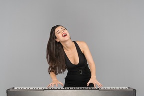 Una mujer joven feliz disfrutando tocando el piano