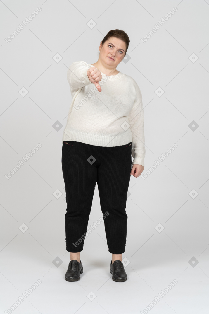 Mulher rechonchuda com roupas casuais mostrando o polegar para baixo