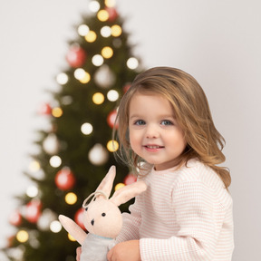 漂亮的小女孩，与她的兔子等待圣诞老人