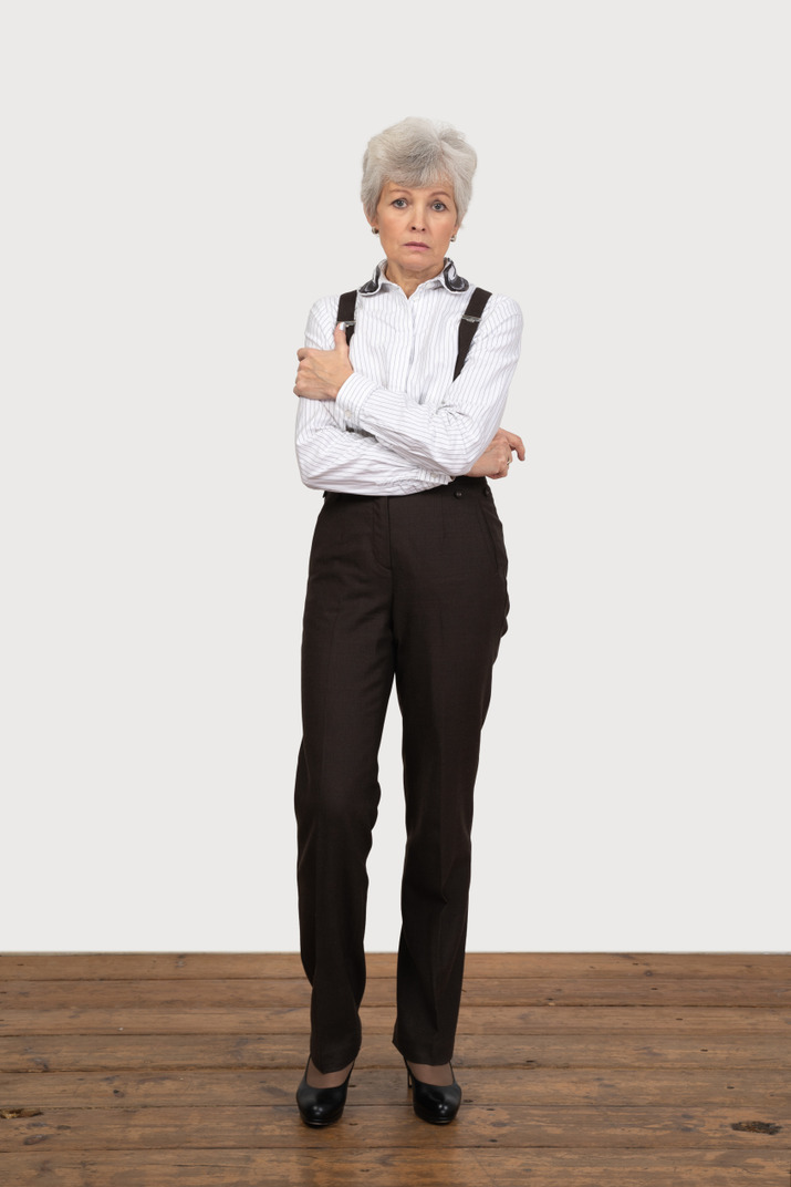 Front view of an old lady in office clothing crossing her hands