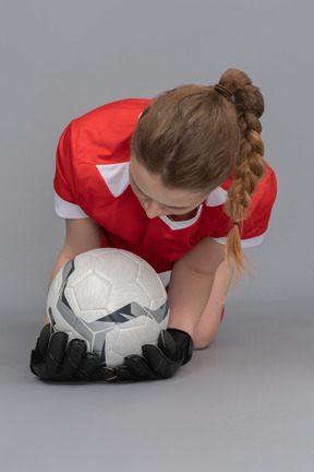 A female goalkeeper catching a ball