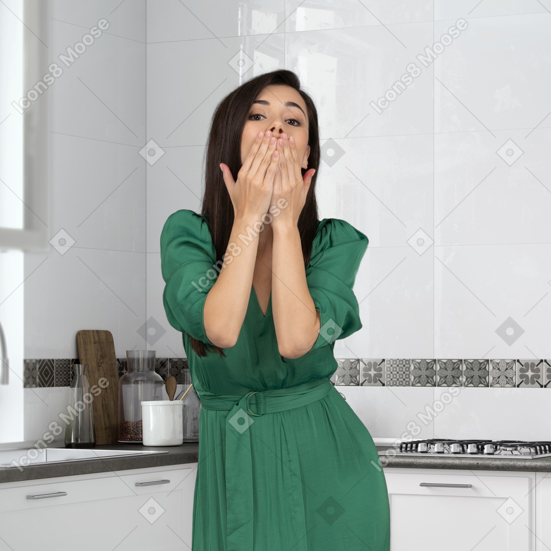 A woman in a green dress blowing a kiss