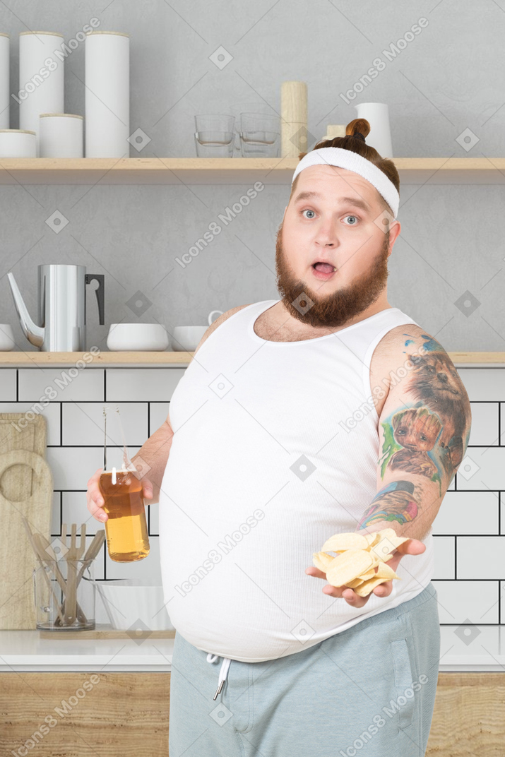 Hombre sosteniendo un sándwich y una botella de jugo