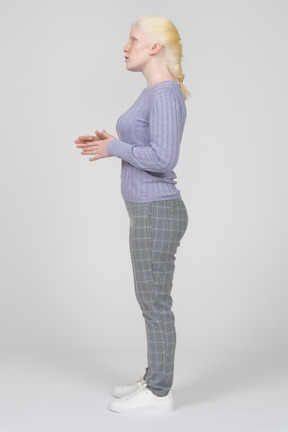 Side view of a young woman speaking with her hands raised