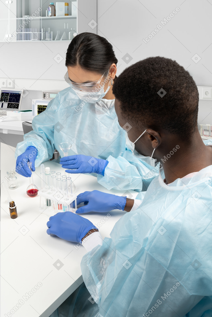 Lab workers sitting at the desk with tubes and flasks