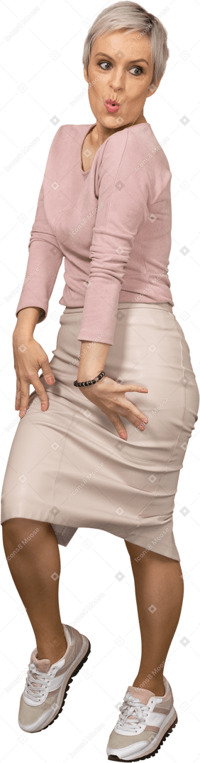 Vista frontal de una mujer en ropa casual posando y haciendo muecas