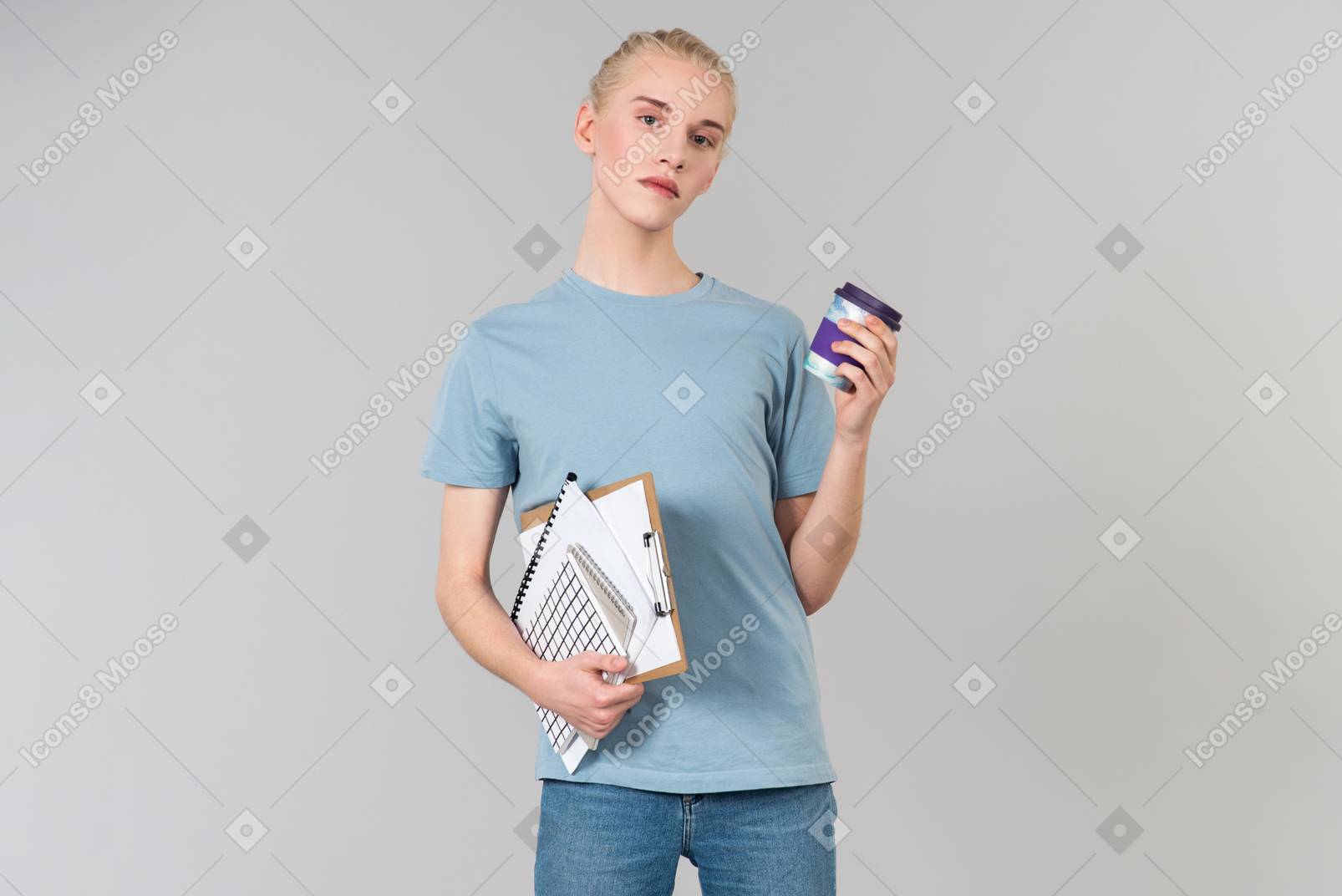 Cute young androgynous guy in a light blue t-shirt and blue jeans, on his way to college